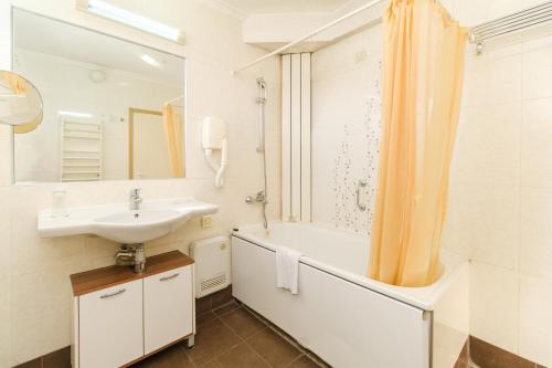 a bathroom with a sink and a tub and a shower at Noviz Hotel in Plovdiv