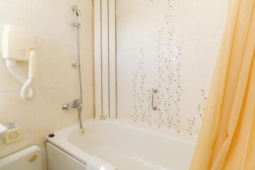 a bathroom with a shower and a bath tub at Noviz Hotel in Plovdiv