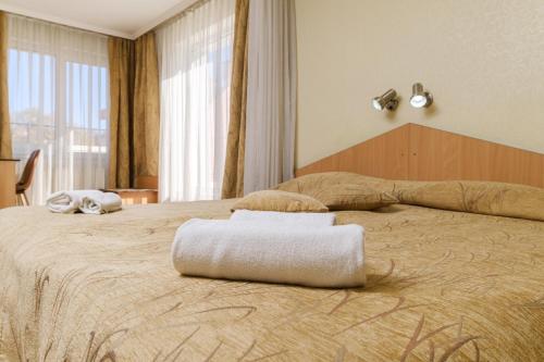 a hotel room with two beds with towels on them at Noviz Hotel in Plovdiv