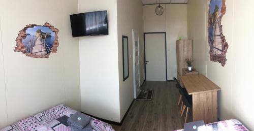 a living room with a couch and a television on a wall at Pokoje nad Nysą Olszyna in Olszyna