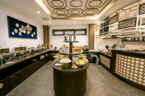 a restaurant with a counter with dishes on it at 22Land Residence Hotel & Spa Hanoi in Hanoi