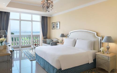 a bedroom with a white bed and a balcony at Kempinski Hotel & Residences Palm Jumeirah in Dubai