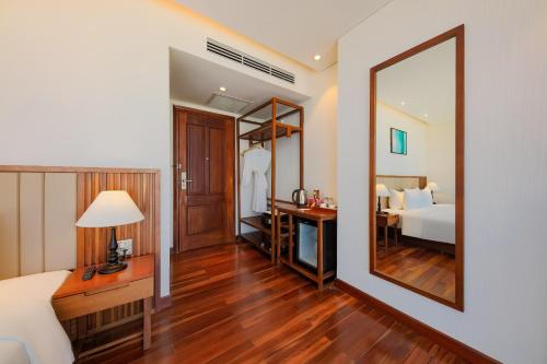 a bedroom with a bed and a large mirror at Green Beach Hotel Nha Trang in Nha Trang