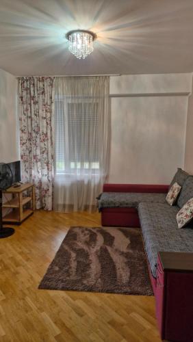 a living room with a bed and a chandelier at Аэропорт Апартаменты Комфорт in Chişinău