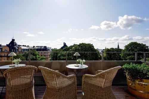 a patio with chairs and tables on a balcony at Villa Dahlia in Stockholm