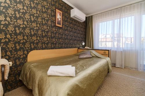 a bedroom with a bed with a towel on it at Noviz Hotel in Plovdiv