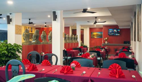 a restaurant with red tables and chairs with red napkins at Khmer Mansion Boutique Hotel in Siem Reap