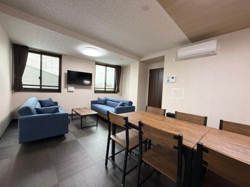 a conference room with a table and chairs and a couch at PRISM Inn ZOSHIKI Kamata in Tokyo