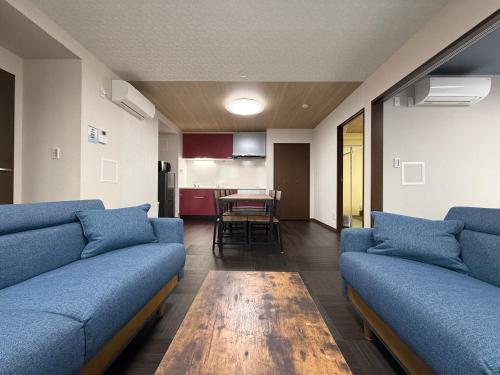 a living room with blue couches and a table at PRISM Inn ZOSHIKI Kamata in Tokyo