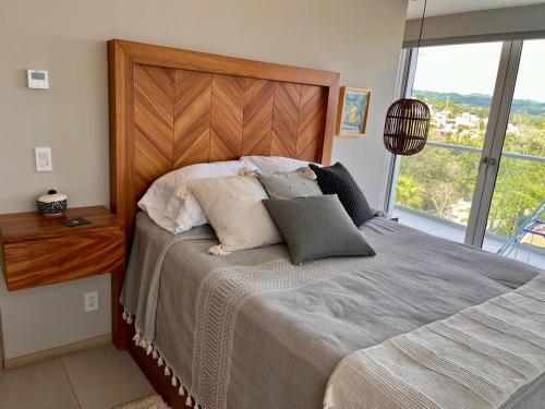 a bedroom with a large bed with a large window at Rooftop Pool Suites Vallarta in Bucerías