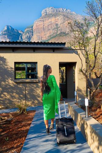 a woman in a green dress walking with a suitcase at Marepe Mountain View in Kampersrus AH