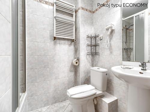 a white bathroom with a toilet and a sink at Afrodyta Spa in Świnoujście