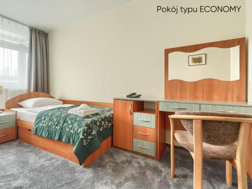 a bedroom with a bed and a desk and a chair at Afrodyta Spa in Świnoujście