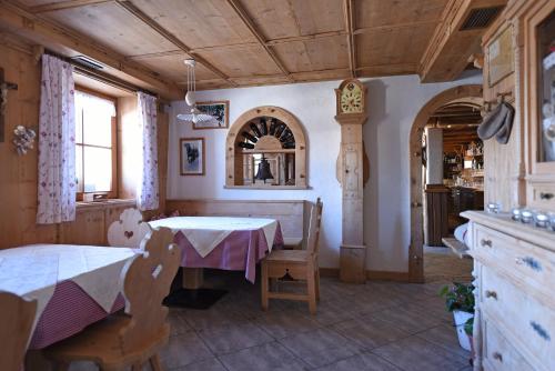 a dining room with a table and chairs and a clock at Agriturismo Soleseid in San Vigilio Di Marebbe