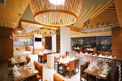a restaurant with tables and chairs and a bar at Regenta Suites Gurugram, Sector 49 Sohna Road in Gurgaon