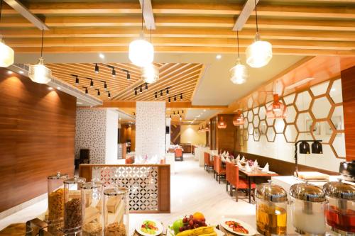 a restaurant with wooden ceilings and tables with food at Regenta Suites Gurugram, Sector 49 Sohna Road in Gurgaon