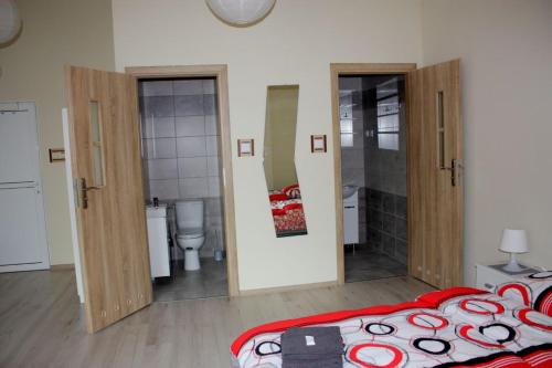 a bedroom with a bed and a bathroom with a toilet at Pokoje nad Nysą Olszyna in Olszyna