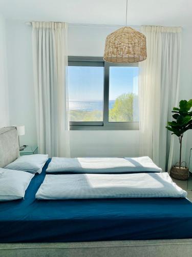 a bedroom with a large bed with a large window at Coral Bay Garden in Peyia
