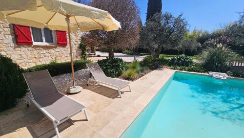 deux chaises et un parasol à côté d'une piscine dans l'établissement Chambre d'Hôtes 
