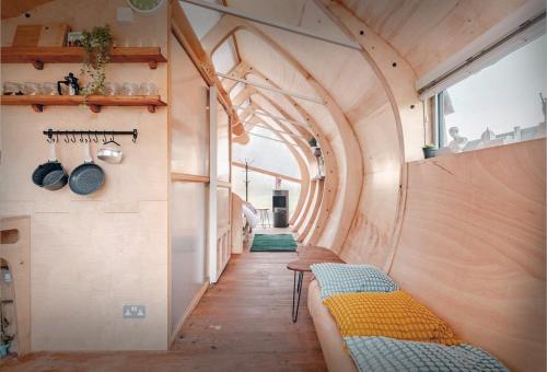 a tiny house with an archway and benches in the hallway at Architect-Designed Rural Cabin - Year Round Retreat in Market Drayton