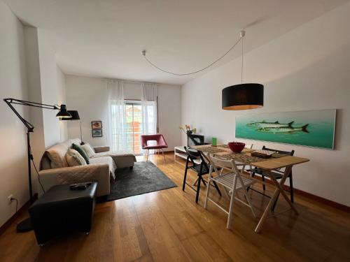 a living room with a table and a couch at Apartamento do Atlântico in Ponta Delgada