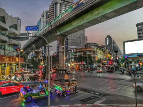 a busy city street with cars and carts at Nysa Hotel Bangkok Sukhumvit 11 in Bangkok