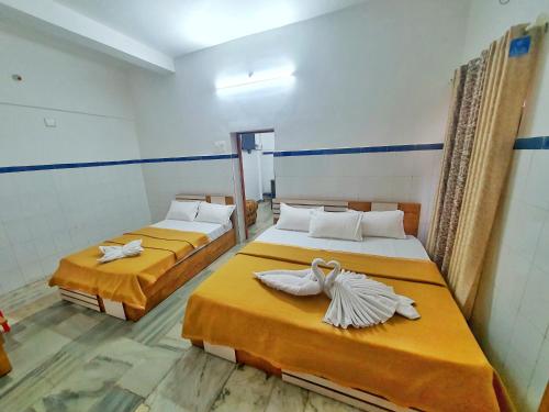 a room with two beds with towels on them at kollam Beach Resort in Kollam