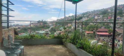 a balcony with a view of a city at Hut on the Hill Baguio City in Baguio
