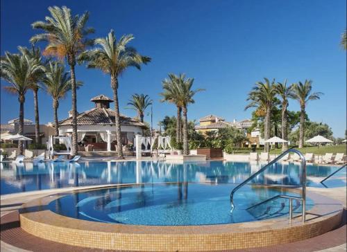 ein Pool in einem Resort mit Palmen in der Unterkunft 3 Bed Villa Mar Menor Golf Heated Pool Terrace in Torre-Pacheco