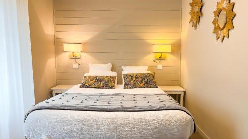 a bedroom with a bed with two pillows at Logis hôtel Restaurant Le Faisan Dore in Fontenai-sur-Orne