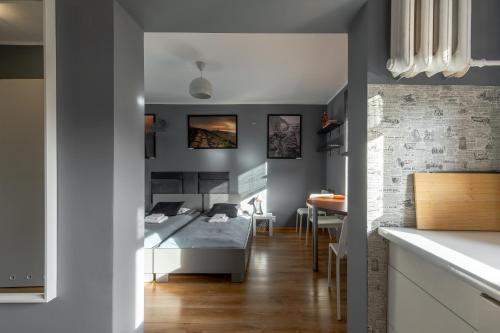 a bedroom with a bed and a dining room at Apartament w Karkonoszach in Piechowice