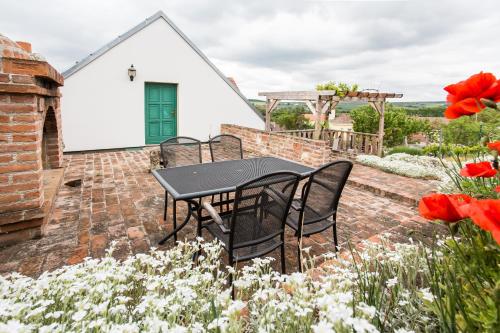 a table and chairs on a brick patio with flowers at Vinařský dům Sedlec in Sedlec