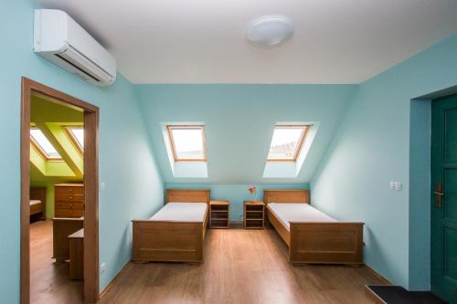 a room with two beds and two windows at Vinařský dům Sedlec in Sedlec