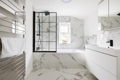 a white bathroom with a tub and a sink at Charles Hope Salisbury Residence in Salisbury