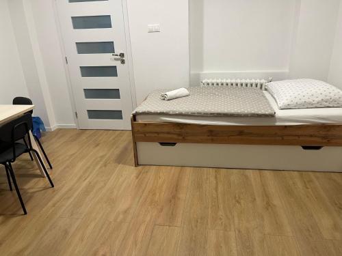 a bedroom with a bed and a wooden floor at Penzión pri Kaštieli in Bratislava