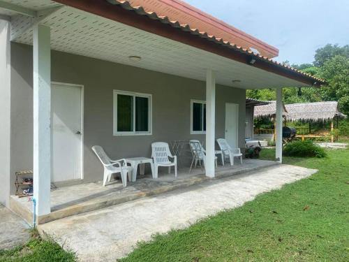 a porch of a house with chairs and a table at Near & Far in Ko Lanta