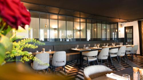 a row of tables and chairs in a restaurant at Logis hôtel Restaurant Le Faisan Dore in Fontenai-sur-Orne