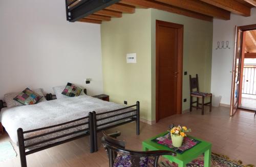 a bedroom with a bed and a table in a room at Cascina Amrit CAV in Borghetto Lodigiano