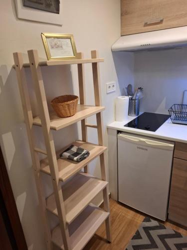 a kitchen with a wooden shelf next to a counter at Studio Posh with garden in Kolonaki in Athens