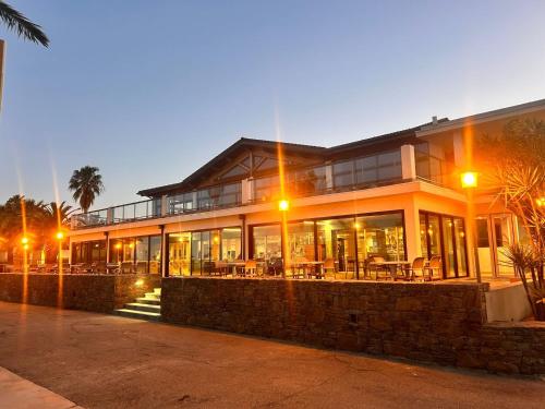 un bâtiment avec des tables et des chaises devant lui dans l'établissement Hotel & Restaurant San Pellegrino, à Folelli