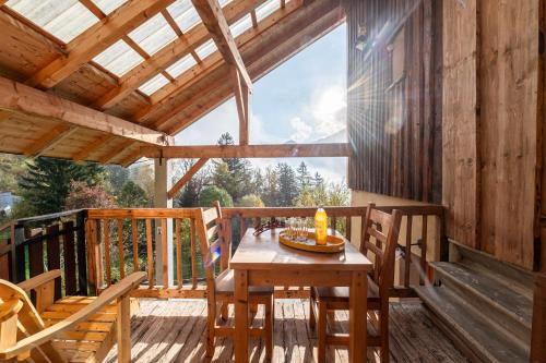 - une terrasse couverte en bois avec une table et des chaises dans l'établissement Chalet La Vourze, à Queige