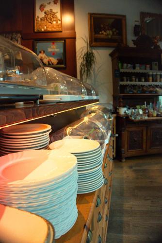 a buffet line with white plates on a counter at Schillers Hotel & Café - GARNI - in Lüdenscheid