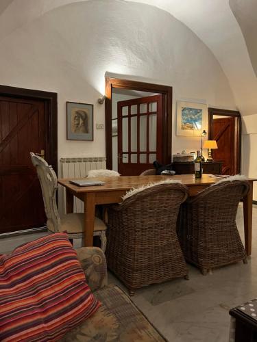 a dining room with a wooden table and wicker chairs at Casa Venezia in Airole, Liguria, Italy in Airole