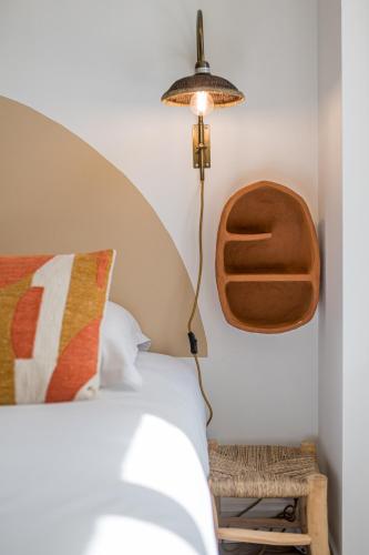 a bedroom with a bed and a lamp on the wall at Villa Robs - Appartements tout confort, TV connectée, Haut débit, Localisation idéale - Courts séjours & Affaires in Caen