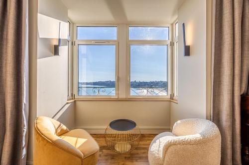 a living room with two chairs and a window at Restaurant Hotel Didier Méril in Dinard