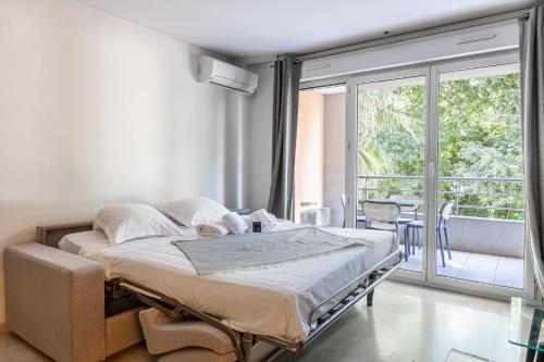 une chambre avec un lit et un balcon dans l'établissement Magnificent apartment with parking - AC-balcony, à Cannes