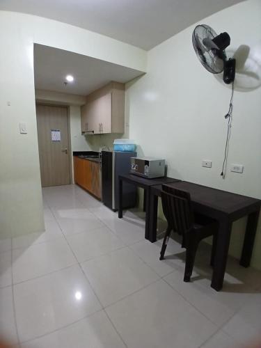 un soggiorno con un tavolo e una cucina di Breeze Residences a Manila