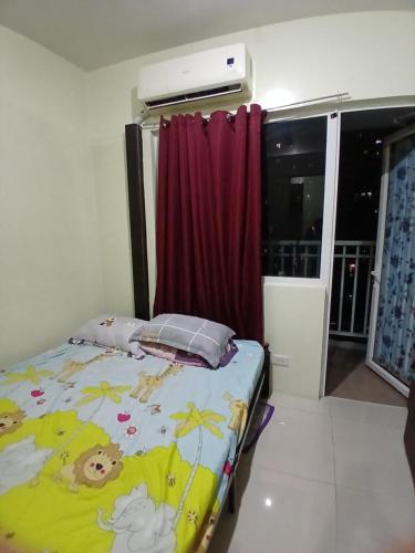 una piccola camera da letto con un letto con una coperta di Breeze Residences a Manila