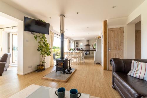 a living room with a couch and a stove at Holly Cottage in Cranleigh