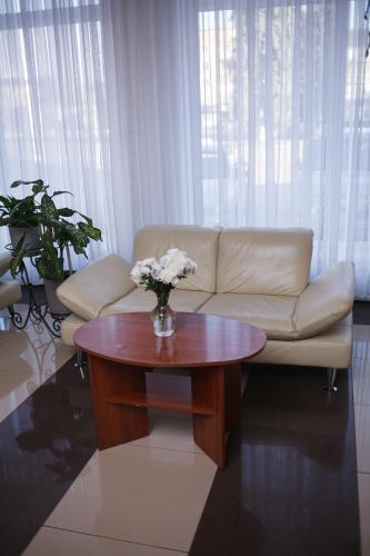 a living room with a couch and a table with flowers at Hotel LUDMIR in Volodymyr-Volynsʼkyy